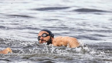 Chay Suede pratica natação no mar mesmo com tempo nublado no Rio